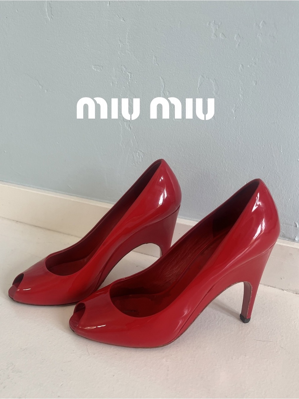 Miu Miu red patent leather peep-toe pumps featuring a high-shine finish